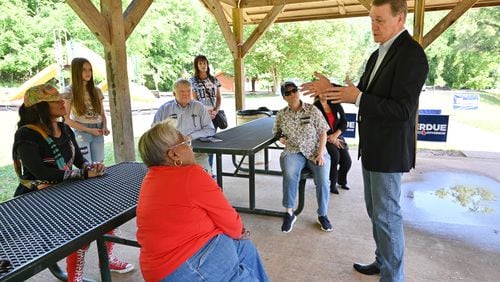 Former U.S. Sen. David Perdue talks to his supporters at a campaign event earlier this month at Sell's Mill Park in Hoschton. Perdue, trying to unseat Gov. Brian Kemp in the GOP primary, has been trailing by double digits in polls while also lagging well behind in fundraising. His campaign, however, is looking for reasons to be optimistic as it analyzes data from the turnout during early voting. (Hyosub Shin / Hyosub.Shin@ajc.com)