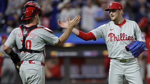 Philadelphia Phillies relief pitcher Jeff Hoffman, right, and catcher J.T. Realmuto (10) celebrate after defeating the New York Mets in a baseball game Friday, Sept. 20, 2024, in New York. (AP Photo/Adam Hunger)