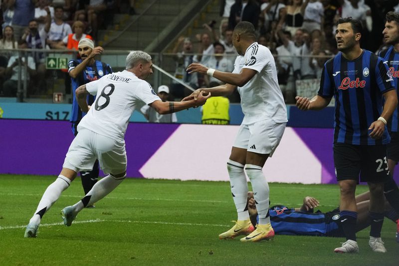 Real Madrid's Federico Valverde, centre left, celebrates with Kylian Mbappe after scoring the opening goal during the UEFA Super Cup Final soccer match between Real Madrid and Atalanta at the Narodowy stadium in Warsaw, Poland, Wednesday, Aug. 14, 2024. (AP Photo/Czarek Sokolowski)