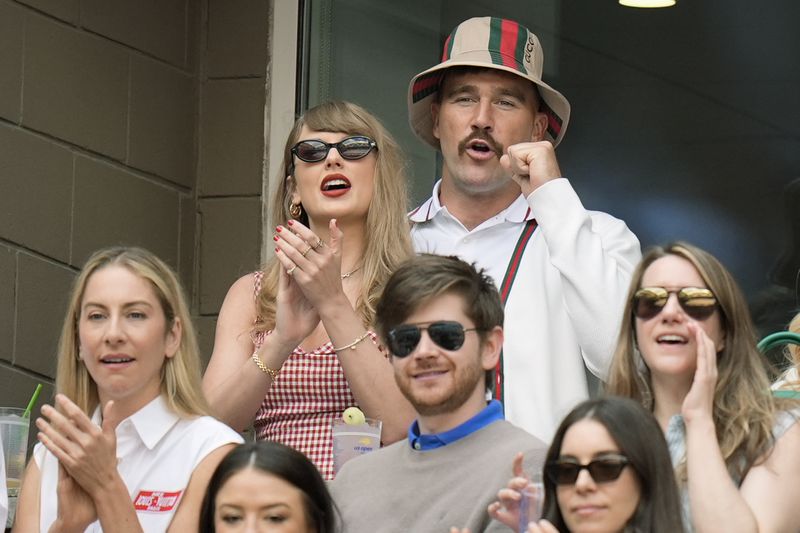 Taylor Swift and Kansas City Chiefs tight end Travis Kelce, cheer as they watch play between Jannik Sinner, of Italy, and Taylor Fritz, of the United States, during the men's singles final of the U.S. Open tennis championships, Sunday, Sept. 8, 2024, in New York. (AP Photo/Seth Wenig)