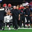 Falcons head coach Raheem Morris (right) watches linebacker Troy Andersen leave the field after an injury Sunday. (Miguel Martinez/ AJC)