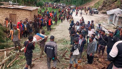 In this photo provides the International Organization for Migration, an injured person is carried on a stretcher to seek medical assistance after a landslide in Yambali village, Papua New Guinea, Friday, May 24, 2024. More than 100 people are believed to have been killed in the landslide that buried a village and an emergency response is underway, officials in the South Pacific island nation said. The landslide struck Enga province, about 600 kilometers (370 miles) northwest of the capital, Port Moresby, at roughly 3 a.m., Australian Broadcasting Corp. reported. (Benjamin Sipa/International Organization for Migration via AP)