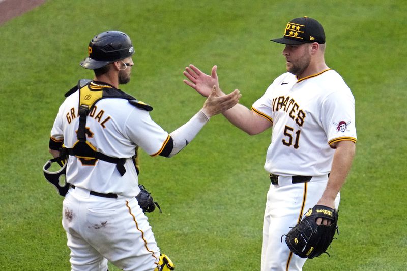 Pittsburgh Pirates relief pitcher David Bednar (51) celebrates with catcher Yasmani Grandal after the team's win over the Atlanta Braves in a baseball game in Pittsburgh, Saturday, May 25, 2024. The Pirates won 4-1. (AP Photo/Gene J. Puskar)