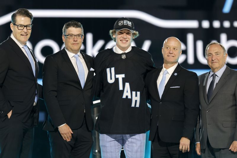 Cole Beaudoin, center, poses after being selected by the Utah Hockey Club during the first round of the NHL hockey draft Friday, June 28, 2024, in Las Vegas. (AP Photo/Steve Marcus)