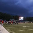 Storm clouds approach the stadium as the Milton defense huddles up against Buford in the first half at Milton High School, Friday, August 16, 2024, in Milton, Ga. (Jason Getz / AJC)