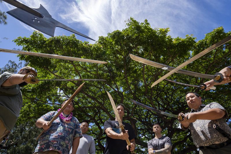 Members of Hawaii Firearms Coalition showcase their halberd, swords and balisong at Kapiolani Park on Saturday, June 22, 2024, in Honolulu, Hawaii. (AP Photo/Mengshin Lin)