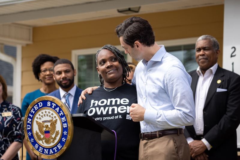 U.S. Sen. Jon Ossoff (right), D-Ga, stands with new homeowner Tanjills Sawyer at a press conference in Hampton on Monday, May 6, 2024. The conference, which announced federal funds for housing in Clayton County, took place in front of Sawyer’s house, built by Southern Crescent Habitat for Humanity. (Arvin Temkar / AJC)