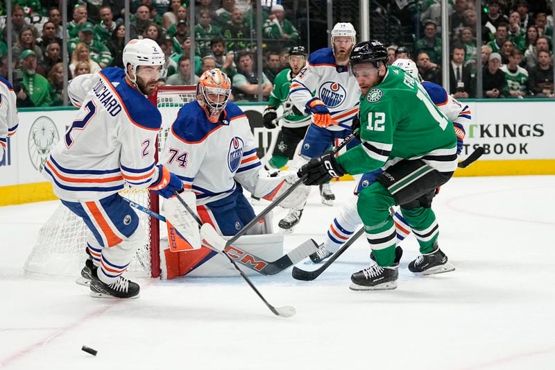 Edmonton Oilers' Evan Bouchard (2) and Stuart Skinner (74) and Dallas Stars center Radek Faksa (12) watch the puck during the first period of Game 1 of the Western Conference finals in the NHL hockey Stanley Cup playoffs Thursday, May 23, 2024, in Dallas. (AP Photo/Tony Gutierrez)