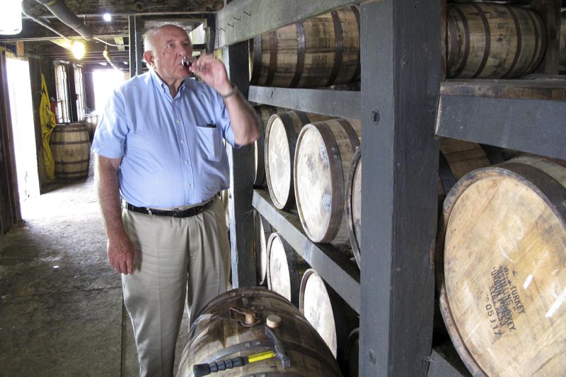 FILE- Wild Turkey master distiller Jimmy Russell takes a sip of bourbon drawn from the barrel at a warehouse near Lawrenceburg, Ky., Aug. 22, 2014. (AP Photo/Bruce Schreiner, File)