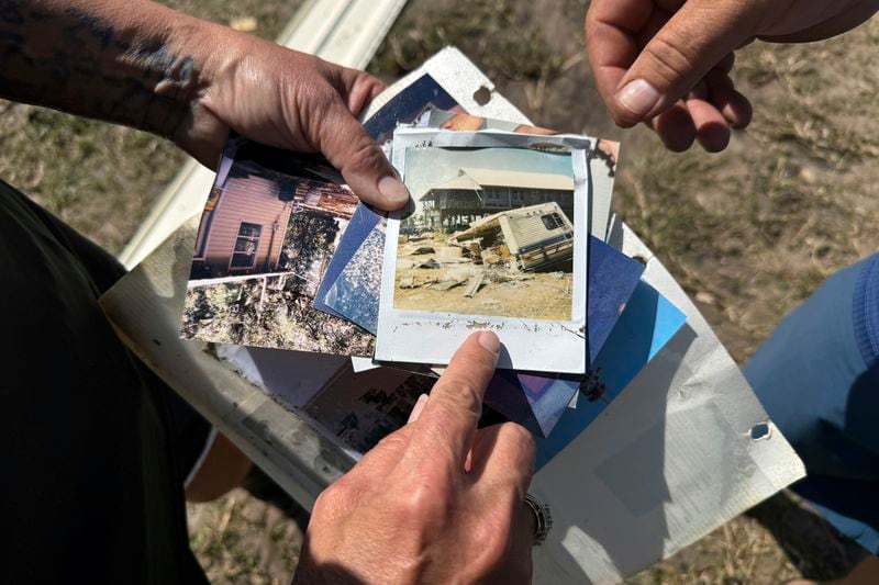 Leslie and J.D. High hold photos they found in the debris that Hurricane Helene left near their home in Dekle Beach in rural Taylor County, Fla., Friday, Sept. 27, 2024. Among the photos was a polaroid showing damage from a storm known as the "Storm of the Century" that hit the area in March, 1993. (AP Photo/Kate Payne)