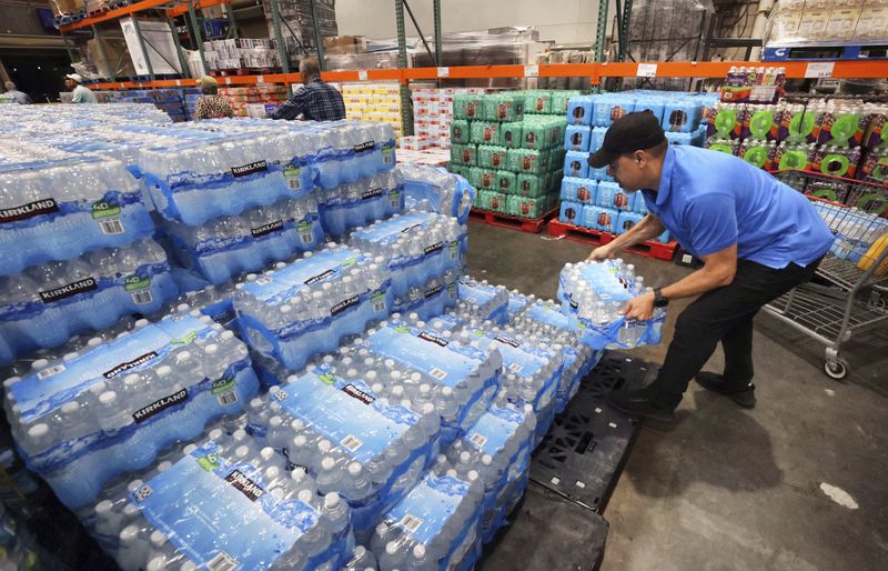 A customer grabs a case of water at the Costco in Altamonte Springs, Fla., Monday, Oct. 7, 2024, as residents prepare for the impact of Hurricane Milton. (Joe Burbank/Orlando Sentinel via AP)