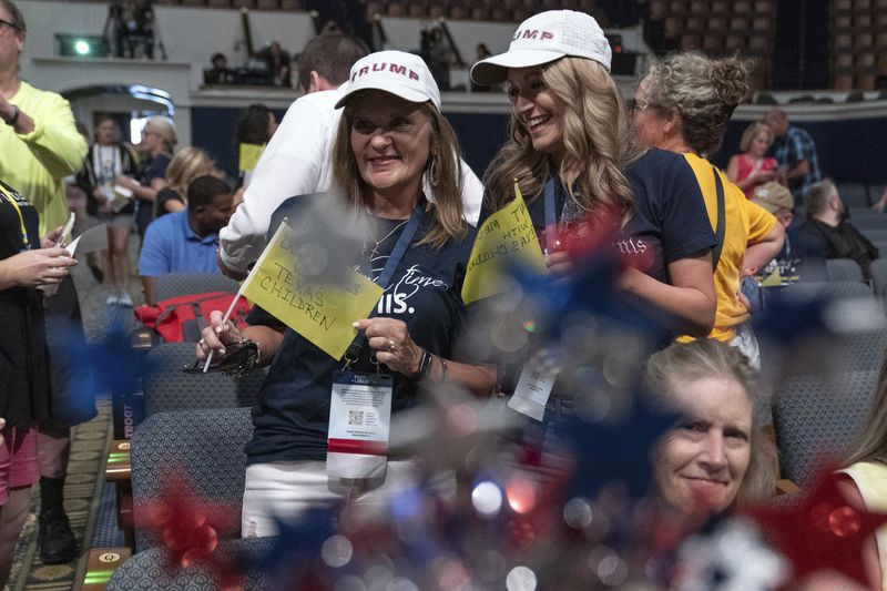 Attendees hold signs during the Moms for Liberty National Summit in Washington, Saturday, Aug. 31, 2024. (AP Photo/Jose Luis Magana)