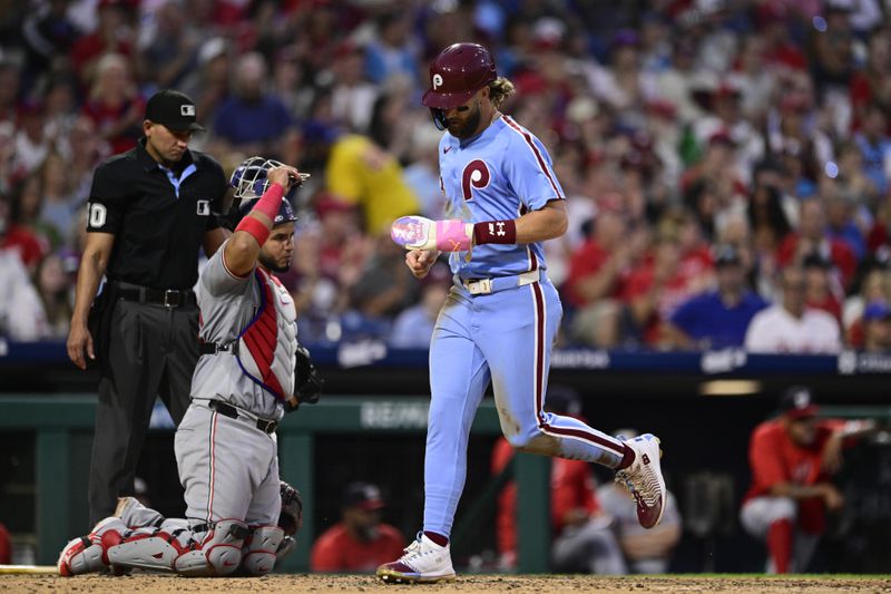 Philadelphia Phillies' Bryce Harper, right, scores on a single hit by Nick Castellanos off Washington Nationals' Eduardo Salazar during the fourth inning of a baseball game, Thursday, Aug. 15, 2024, in Philadelphia. (AP Photo/Derik Hamilton)