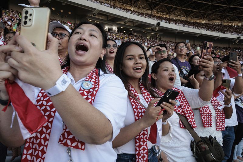 People sing together as Pope Francis arrives for a holy mass at the Gelora Bung Karno Stadium in Jakarta, Thursday, Sept. 5, 2024. (Yasuyoshi Chiba/Pool Photo via AP)