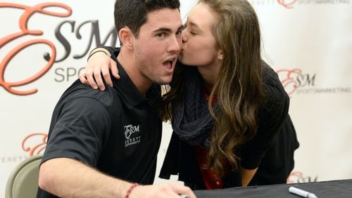 Daughtry St. John, of Columbus, kisses Aaron Murray as they pose for a photographer during his signing event at Georgia Square Mall in Athens on Saturday, December 14, 2013. St. John left home at 6 a.m. today to meet Aaron Murray. St. John had her knee surgery on the same day as Aaron Murray had his knee surgery. Former Georgia quarterback Aaron Murray is signing autographs at the Georgia Square Mall and part of the proceeds will benefit Extra Special People, an organization that enhances the lives of children with developmental disabilities.