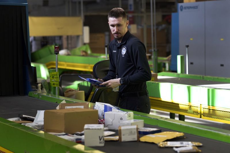 FILE - U.S. Customs and Border Protection technician Czar Zeman examines overseas parcels after they were scanned at the agency's overseas mail inspection facility at Chicago's O'Hare International Airport Feb. 23, 2024, in Chicago. (AP Photo/Charles Rex Arbogast, File)