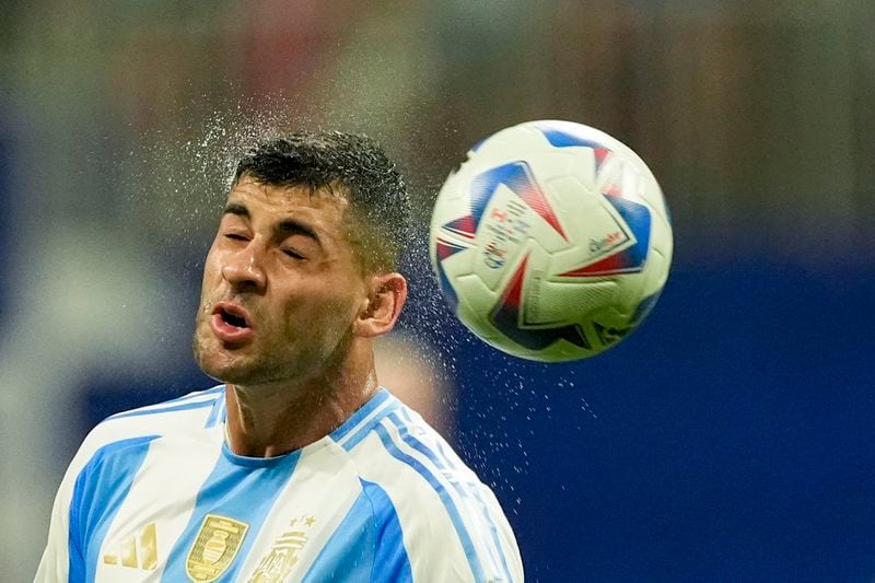 Argentina's Cristian Romero goes for a header during a Copa America Group A soccer match against Canada in Atlanta, Thursday, June 20, 2024. (AP Photo/Mike Stewart)