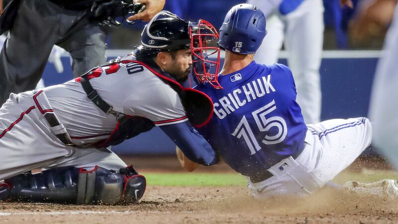 Atlanta Braves catcher Travis d'Arnaud tags out Toronto Blue Jays' Randal Grichuk during the sixth inning of a baseball game Saturday, May 1, 2021, in Dunedin, Fla. (AP Photo/Mike Carlson)