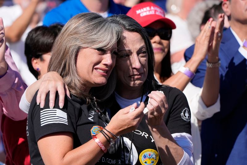 Kelly Comperatore-Meeder, left, and Dawn Comperatore-Schafer, sisters of firefighter Corey Comperatore, who died as he shielded family members from gunfire, cry at a campaign event for Republican presidential nominee former President Donald Trump, at the Butler Farm Show, the site where a gunman tried to assassinate Trump in July, Saturday, Oct. 5, 2024, in Butler, Pa. (AP Photo/Alex Brandon)