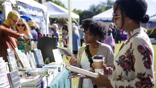 Candice Nicole (left) and Shaliss Monet (right) browse through books during the 2022 Decatur Book Festival. After a one-year hiatus, the festival returns Oct. 4-5. (Christina Matacotta for The Atlanta Journal-Constitution)