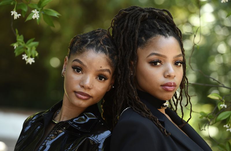 Halle Bailey (left) and her sister Chloe of the R&B duo Chloe X Halle pose together for a portrait in their backyard, Thursday, May 28, 2020, in Los Angeles. (AP Photo/Chris Pizzello)