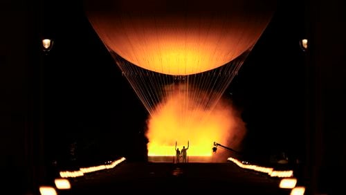 Teddy Riner and Marie-Jose Perec watch as the cauldron rises in a balloon in Paris, France, during the opening ceremony of the 2024 Summer Olympics, Friday, July 26, 2024. (AP Photo/Vadim Ghirda)