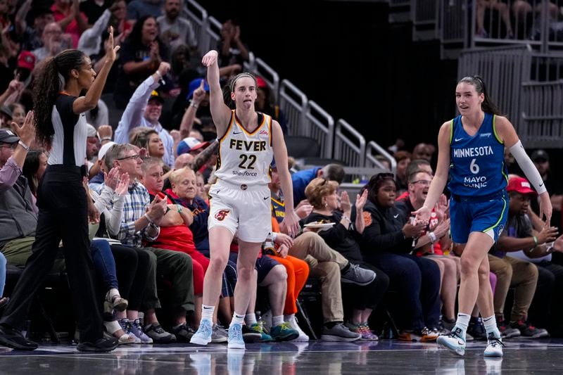 Indiana Fever guard Caitlin Clark (22) reacts after a three-point basket in front of Minnesota Lynx forward Bridget Carleton (6) in the first half of a WNBA basketball game in Indianapolis, Friday, Sept. 6, 2024. (AP Photo/Michael Conroy)