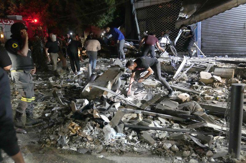 People work to clear debris after an airstrike that hit an apartment building in Beirut, Lebanon, Thursday, Oct. 3, 2024. (AP Photo/Hussein Malla)