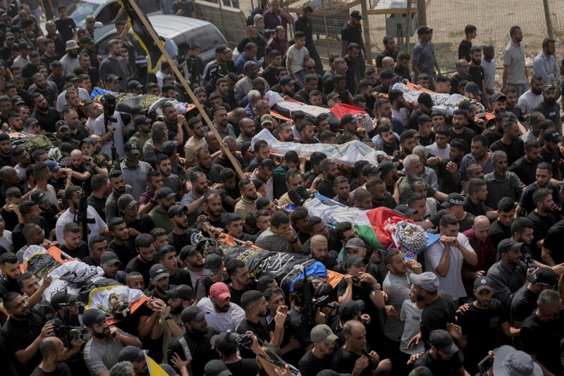 Mourners carry the bodies of Palestinian men who were killed during an Israeli military operation, some draped in the Palestinian flags and the Islamic Jihad militant group, during their funeral in Jenin, West Bank, Friday, Sept. 6, 2024. (AP Photo/Nasser Nasser)