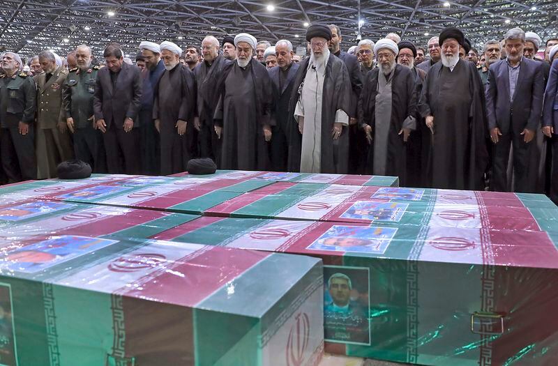 In this photo released by the office of the Iranian supreme leader, Supreme Leader Ayatollah Ali Khamenei, center right with black turban, leads a prayer over the flag-draped coffins of the late President Ebrahim Raisi and his companions who were killed in a helicopter crash on Sunday in a mountainous region of the country's northwest, at the Tehran University campus, during a funeral ceremony for them in Tehran, Iran, Wednesday, May 22, 2024. (Office of the Iranian Supreme Leader via AP)