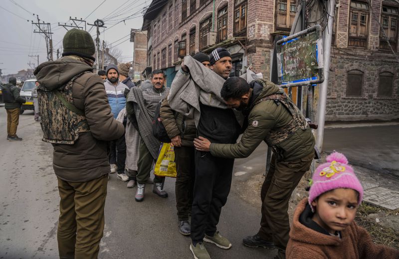 A child looks on as Indian policemen frisk Kashmiri pedestrians during a surprise security check in Srinagar, Indian controlled Kashmir, Monday, Jan. 9, 2023. (AP Photo/Mukhtar Khan, File)