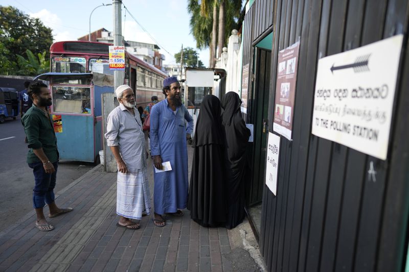 People stand in a queue to cast their votes in Colombo, Sri Lanka, Saturday, Sept. 21, 2024. (AP Photo/Eranga Jayawardane)