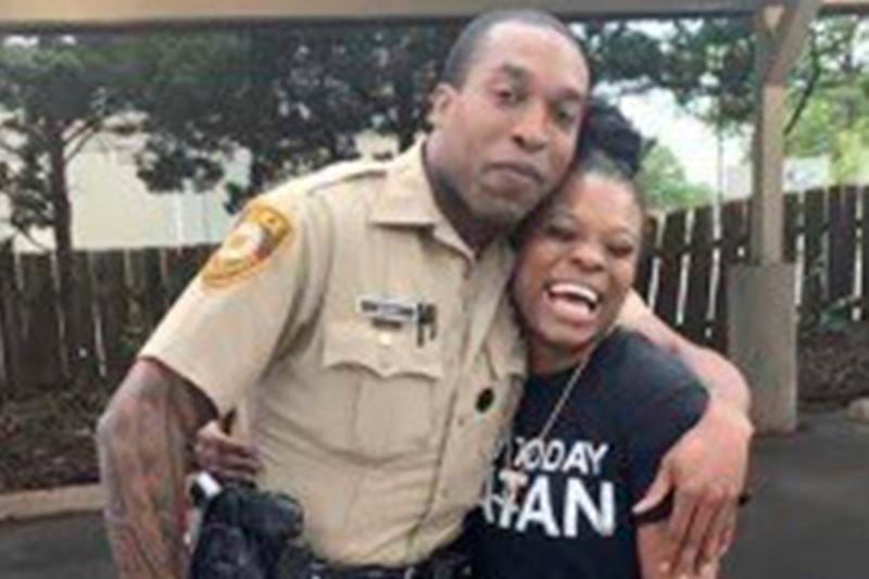 In this undated photo provided by Charlene Jefferson in August 2024, Travis Brown, when he was St. Louis County police officer, stands with Danielle Oliver. Brown, a Ferguson Police officer, suffered a severe brain injury after he was knocked to the ground Friday, Aug. 9, 2024, during a protest in Ferguson, Mo., on the 10th anniversary of the shooting death of Michael Brown. (Charlene Jefferson via AP)