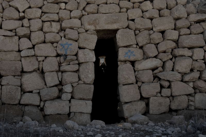 A stone house is defaced with Israeli settlers' graffiti in the West Bank village of Khirbet Zanuta, Thursday, Aug. 29, 2024. Ten months after settlers threatened to kill them if they didn't leave their village, some Palestinian residents are finally home, under a rare court order. (AP Photo/Maya Alleruzzo)