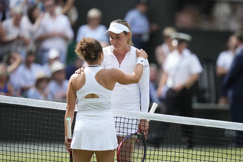 Jasmine Paolini of Italy, left, and Donna Vekic of Croatia get each other at the net after the end of their semifinal match at the Wimbledon tennis championships in London, Thursday, July 11, 2024. Paolini won the match and advances to the final.(AP Photo/Mosa'ab Elshamy)