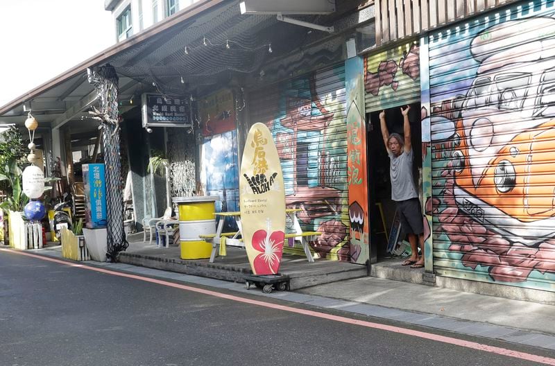 A man opens the door of his shop as Typhoon Krathon approaches to Taiwan in Yilan County, eastern coast of Taiwan, Tuesday, Oct. 1, 2024. (AP Photo/Chiang Ying-ying)