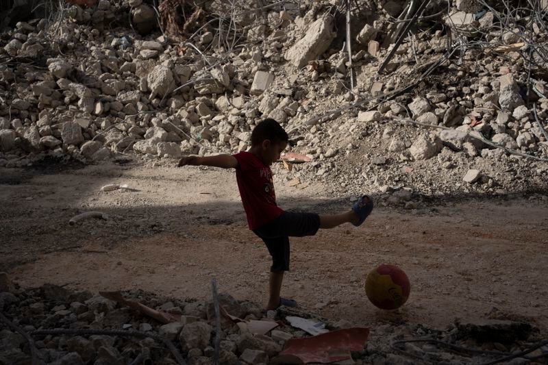 A boy plays with his ball next to debris of a heavily damaged building after an Israeli forces raid in the West Bank city of Jenin, Thursday, May 23, 2024. The Israeli military said Thursday it has completed a two-day operation in the occupied West Bank that the Palestinian Health Ministry says killed 12 Palestinians. Militant groups claimed at least eight of the dead as fighters, one from Hamas and seven from the Al-Aqsa Martyrs Brigade. (AP Photo/Leo Correa)