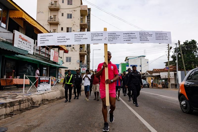 Texas Kadri Moro, the Executive Director of Arise for Justice International, protests with placards nailed on a cross on the street of Accra, Ghana, Thursday Sept 12, 2024. Texas Kadiri Moro is an unusual figure amid the LGBTQ+ rights activists in the coastal West African nation of Ghana. He is heterosexual, married to a woman and a father of six. He is a teacher. And he is a practising Muslim. (AP Photo/Misper Apawu)