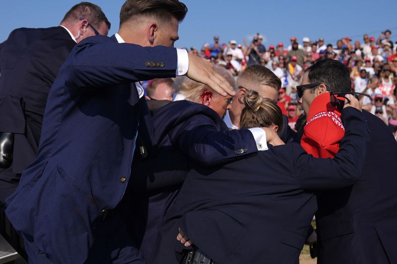 Republican presidential candidate former President Donald Trump is surrounded by U.S. Secret Service agents at a campaign rally, Saturday, July 13, 2024, in Butler, Pa. (AP Photo/Evan Vucci)