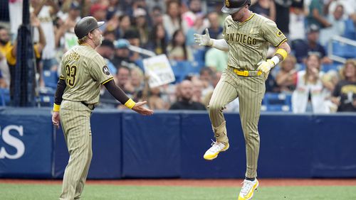 San Diego Padres' Jackson Merrill celebrates with third base coach Tim Leiper (33) after his two-run home run off Tampa Bay Rays starting pitcher Ryan Pepiot during the fourth inning of a baseball game Sunday, Sept. 1, 2024, in St. Petersburg, Fla. (AP Photo/Chris O'Meara)