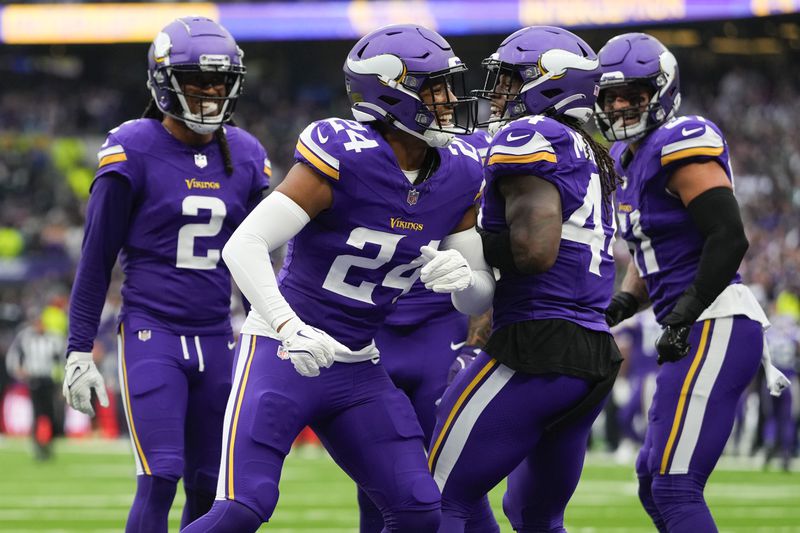 Minnesota Vikings' Camryn Bynum (24), second from left, celebrates an interception with teammates during the first half of an NFL football game against the New York Jets, Sunday, Oct. 6, 2024, at the Tottenham Hotspur stadium in London. (AP Photo/Kirsty Wigglesworth)