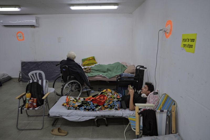 Israelis rest in a residential building bomb shelter to stay safe from rockets fired from Lebanon, in Kiryat Haim, northern Israel, on Tuesday, Sept. 24, 2024. (AP Photo/Baz Ratner)