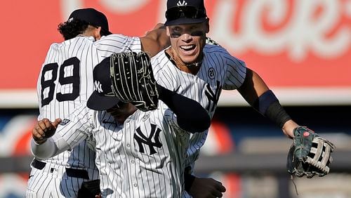 New York Yankees center fielder Aaron Judge, right, celebrates with Juan Soto, front, and Jasson Dominguez (89) after a baseball game against the Boston Red Sox, Sunday, Sept. 15, 2024, in New York. (AP Photo/Adam Hunger)