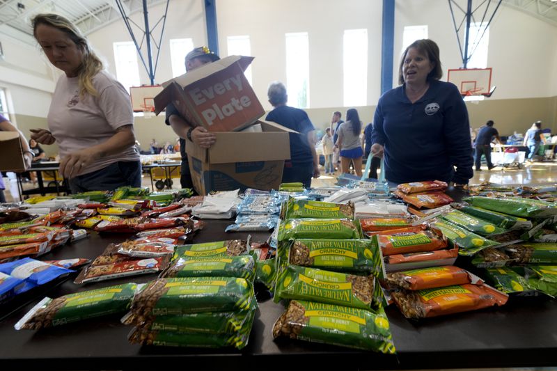 Victims load up on supplies at Watauga High School on Thursday, Oct. 3, 2024, in Boone, N.C. in the aftermath of hurricane Helene. In the final weeks of the presidential election, people in North Carolina and Georgia, influential swing states, are dealing with more immediate concerns: recovering from Hurricane Helene. (AP Photo/Chris Carlson)