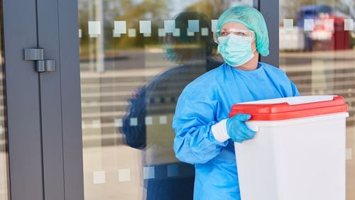 A healthcare worker carries organ for donation in a cooler. (Robert Kneschke/Dreamstime/TNS)