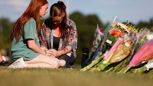 Apalachee High School sophomore Payton Owen, 15, and her mother, Stacey Andrews, offer a prayer by the memorial outside the school on Thursday, Sept. 5, 2024. A 14-year-old is accused of shooting and killing two fellow students and two teachers and injuring nine others at Apalachee High School on Wednesday. (Miguel Martinez/AJC)