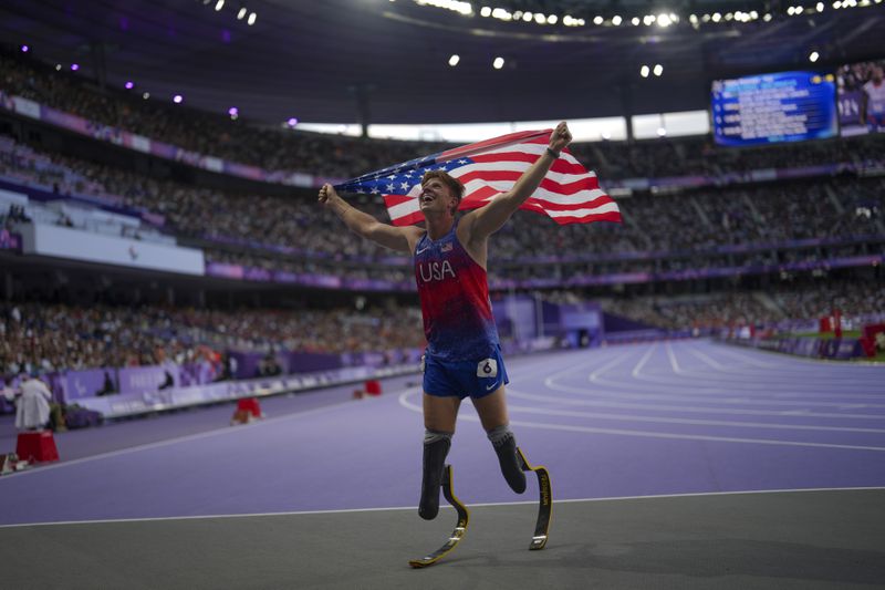 Hunter Woodhall from the U.S. celebrates after winning the men's 400 m. T62 final at the 2024 Paralympics, Friday, Sept. 6, 2024, in Paris, France. (AP Photo/Thibault Camus)