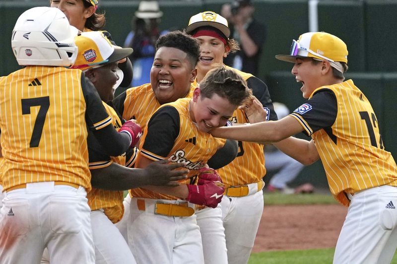 Lake Mary, Fla.'s Hunter Alexander, center, celebrates with teammates after laying down a game-winning, walk-off bunt in the eighth inning of the Little League World Series Championship game against Taiwan in South Williamsport, Pa., Sunday, Aug. 25, 2024. Florida won in eight innings 2-1. (AP Photo/Gene J. Puskar)