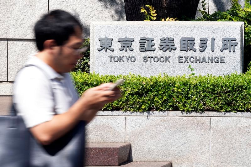 A person walks in front of the Tokyo Stock Exchange building Wednesday, Oct. 2, 2024, in Tokyo. (AP Photo/Eugene Hoshiko)