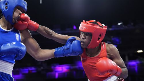 Refugee Olympic Team's Cindy Djankeu hits France's Davina Michel in their women's 75 kg quarterfinal boxing match at the 2024 Summer Olympics, Sunday, Aug. 4, 2024, in Paris, France. (AP Photo/Ariana Cubillos)